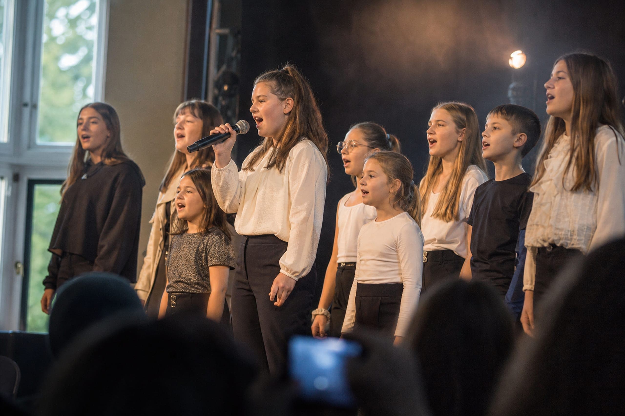 Junger Chor bei einem Auftritt auf einer kleinen Bühne